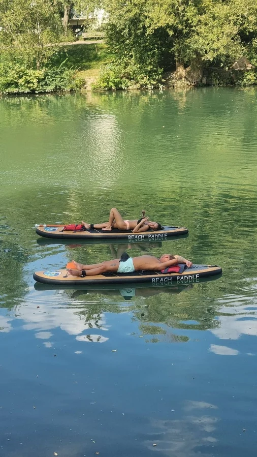 Deux personnes allongées sur un paddle sur la Marne